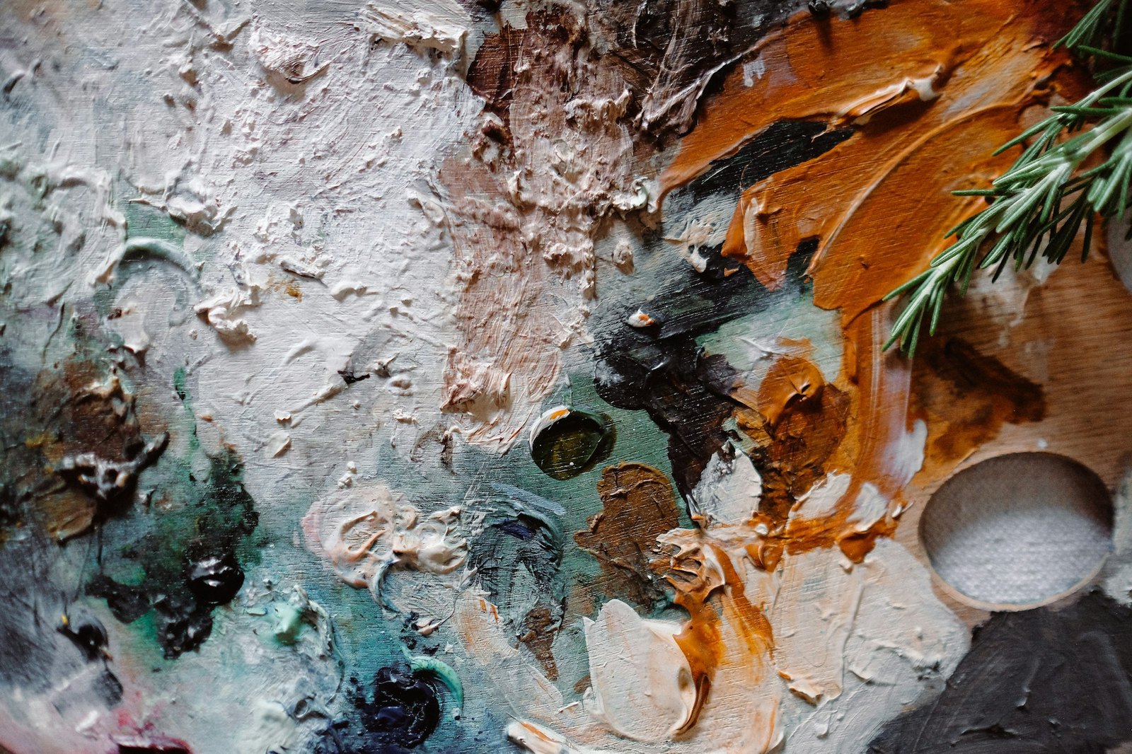 Layers of sea-green, cream and warm copper paint on a textured artist’s palette